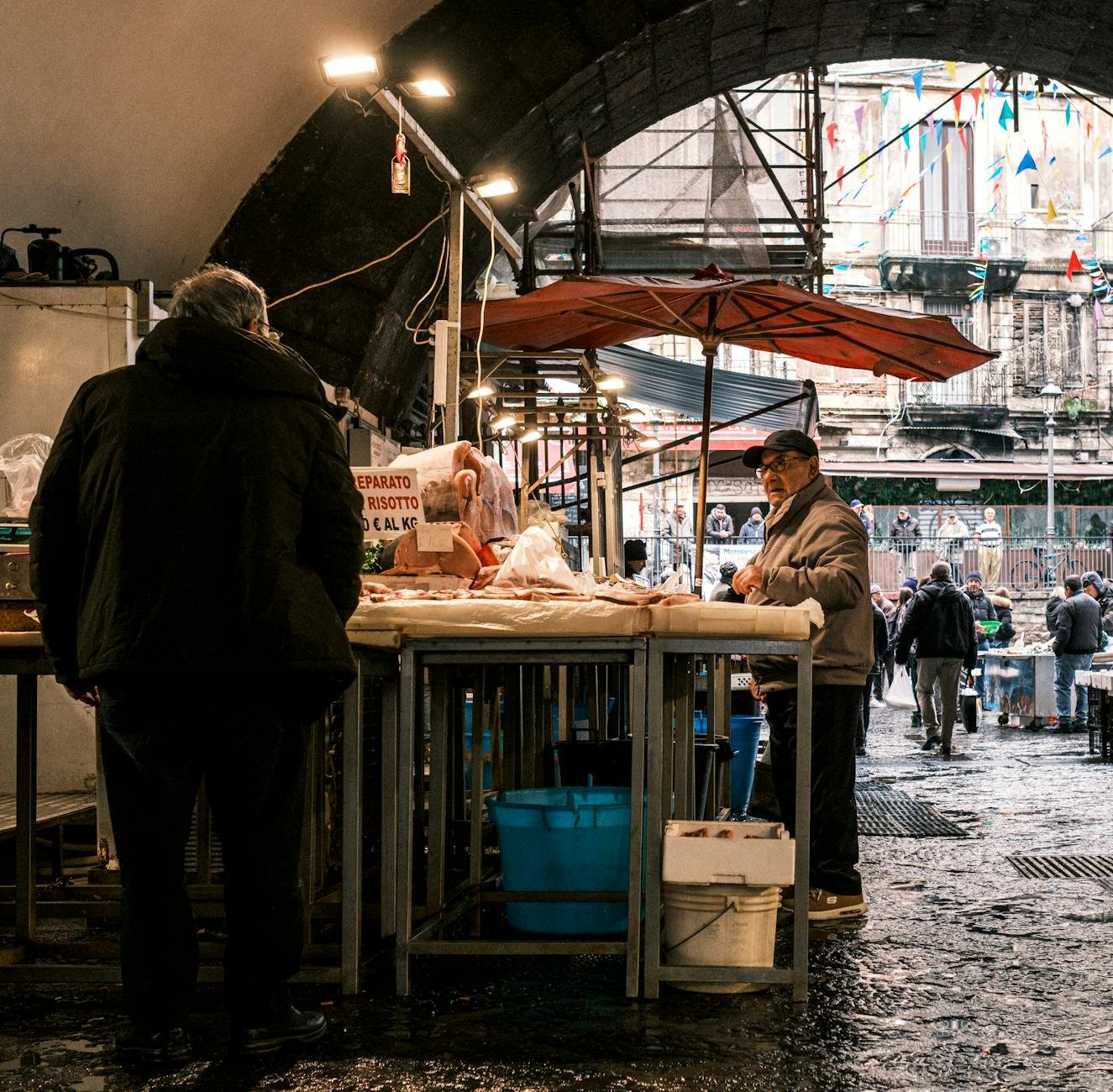 Explore the vibrant atmosphere of a bustling fish market in Catania, Sicily, showcasing local vendors and fresh produce.