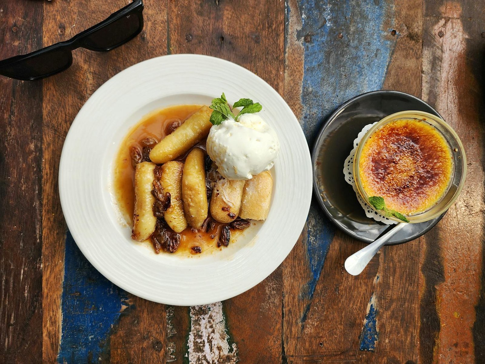 Gourmet French dessert featuring caramelized bananas and crème brûlée served with vanilla ice cream.