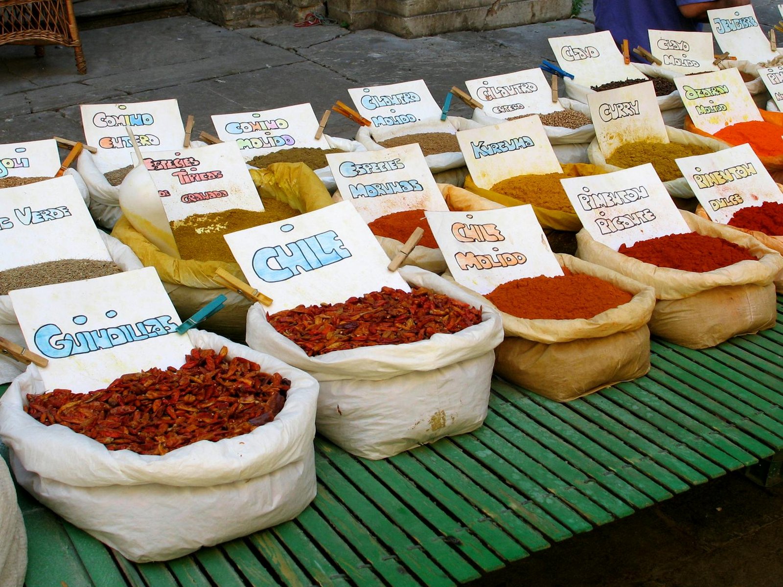 Colorful spices on display at a bustling street market in Granada, Spain.