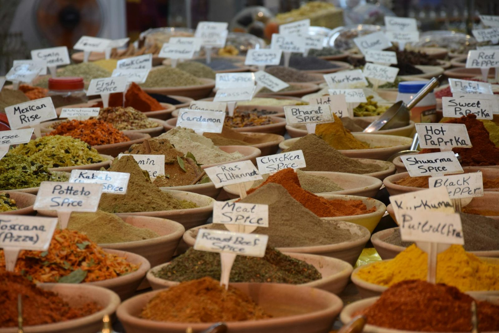 A vibrant assortment of spices in bowls at a bustling Jerusalem market.