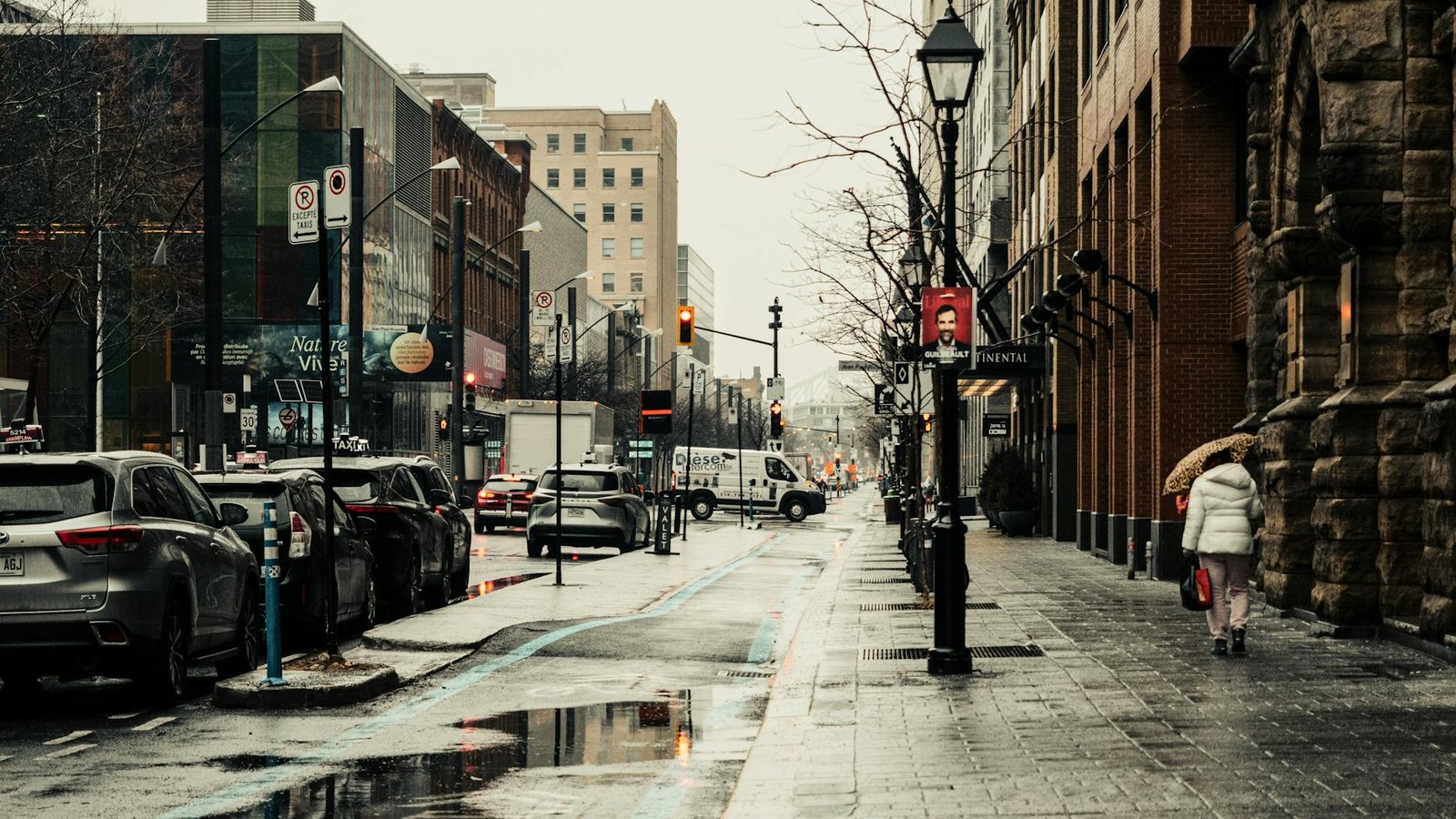A rainy day scene on Sainte-Catherine Street in Montreal capturing urban life and architecture.
