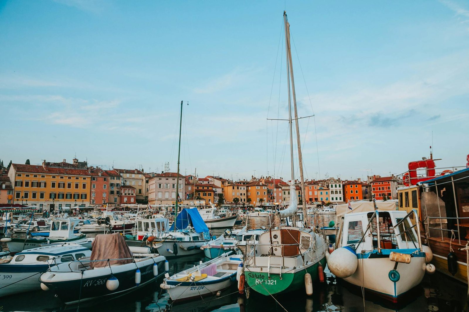 Vibrant marina with docked boats against colorful coastal town backdrop in Croatia.