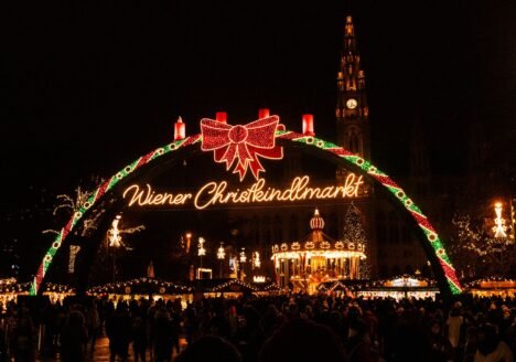 Illuminated Christmas market entrance arch at night in Vienna